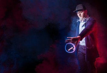 A man with vape. Young guy shows smoke tricks. Vaper. Smoking electronic cigarettes. Colored smoke...