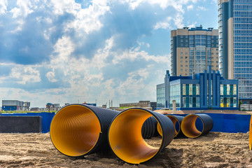 Laying pipes in the ground. Pipes on a construction site. Pipeline. Polymer corrugated tubes....