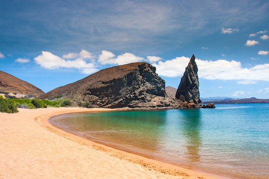 Galapagos Islands. Ecuador. Bartolome Island. Pinnacle Rock. Rocks in the water next to the sandy beach. Blue lagoon. Landscapes of the Galapagos.