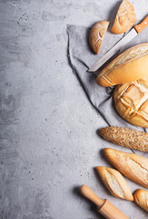 Fresh bread on a gray concrete background. Top view with copy space