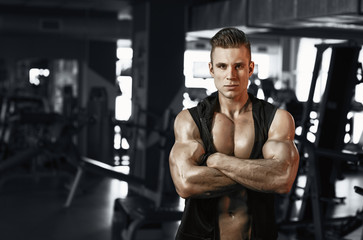 Naklejka na ściany i meble Muscular model sports young man exercising in gym. Portrait of sporty healthy strong muscle. Fitness trainer. Sport workout bodybuilding motivation concept. Sexy torso.