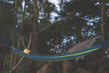 Hammock on a palm tree sunset glare of the sun sea ocean sky shore sand,  Brown hat on the banana...