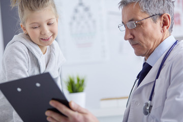 Fototapeta premium Little girl with her mother at a doctor on consultation