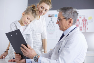 Fototapeta premium Little girl with her mother at a doctor on consultation