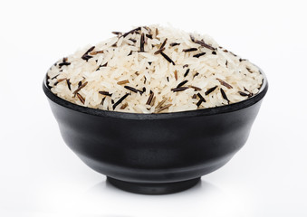 Black bowl of raw organic basmati long grain and wild rice on white background. Healthy food.