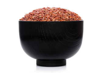 Black bowl of raw organic red rice on white background. Healthy food.