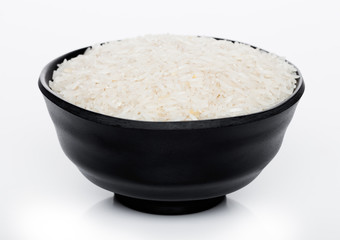 Black bowl of raw organic basmati rice on white background. Healthy food.