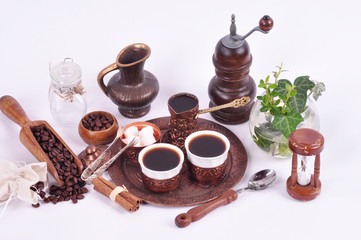 Coffee in copper coasters with accessories for coffee-drinking on a white background.