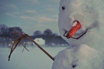 Snowman in a white country at an evening - detailed view