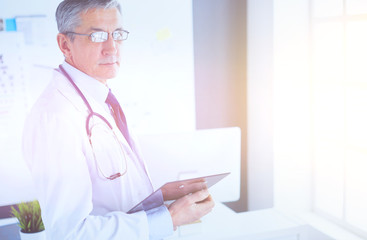 Male doctor writes notes on the clipboard in the hospital