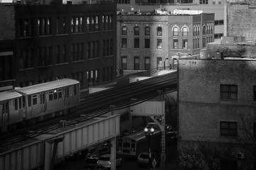 An inbound public train near Clinton Street in the West Loop neighborhood. Main streets in Chicago, Lake Street. Black and white.