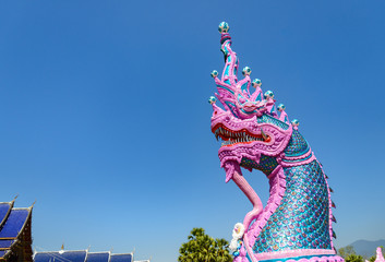 Obraz premium Head of pink queen Naga, legendary creature in buddhist fairytale and culture of south East Asia living in river which shape is similar to snake, serpent or oarfish, statue at temple in Thailand. 