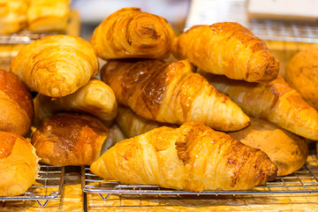 fresh colorful and delicious variety bread or croissant on the mesh and wood shelves in cafe