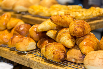 fresh colorful and delicious variety bread or croissant on the mesh and wood shelves in cafe