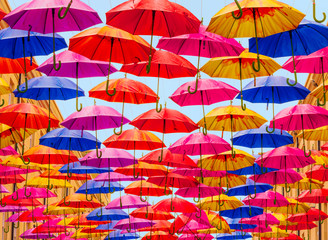 Fototapeta na wymiar Umbrellas hanging in rows over a street
