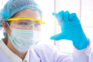 Body past scientist working in laboratory. She is looking in test tube . She is trying and research with blue test tube. Experiment , chemical Photo concept develop and medicine.