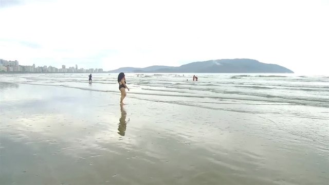 chubby women in black swim suit walking into the water  
