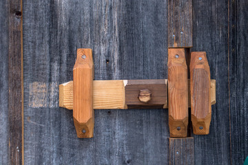 A wooden Latch lock on the door, close up.