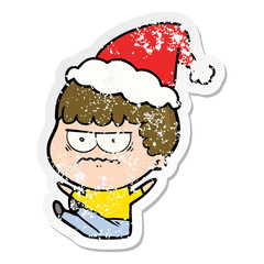 distressed sticker cartoon of a annoyed man wearing santa hat