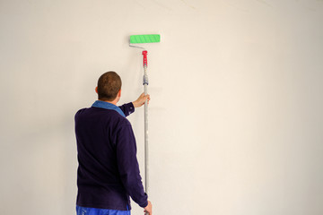 Man painting a white wall.