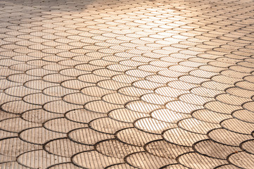 Street tiles. Cobbles at sunset. Sunlight on Cobbled Stones as backround. Sun light and sun rays. Road covered with yellow pavement tile. Tile texture stones Square. Building exterior detail. Empty