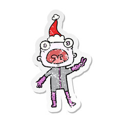 distressed sticker cartoon of a weird alien waving wearing santa hat