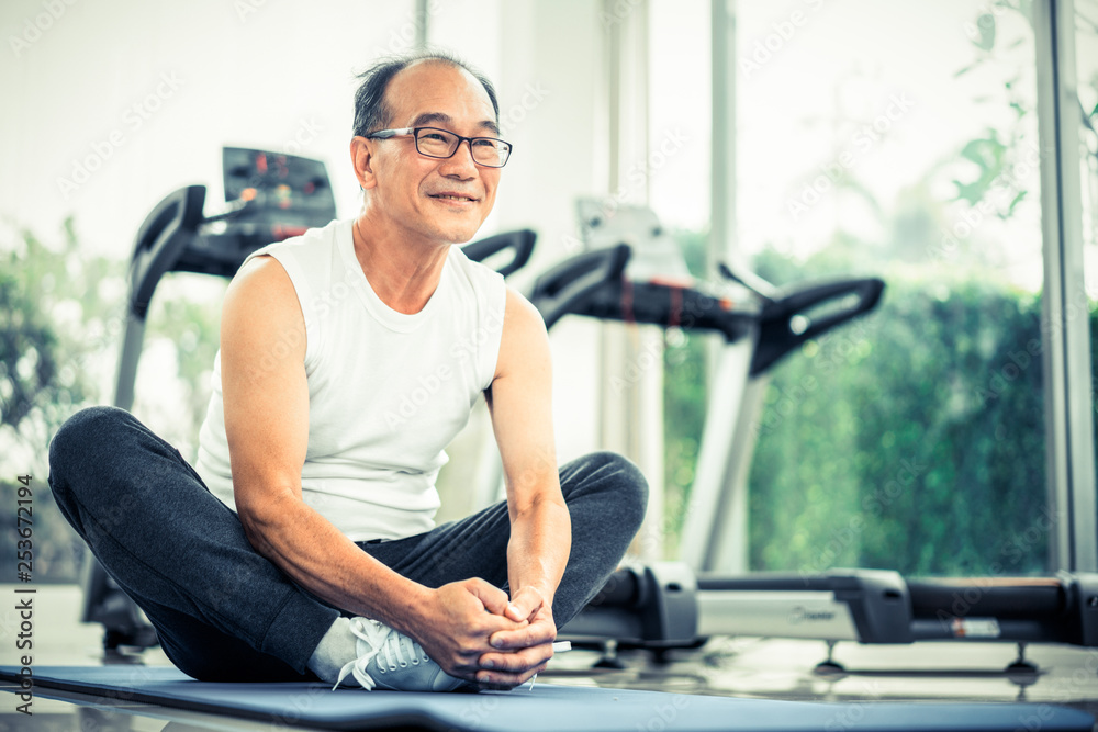 Wall mural senior man do body stretching in fitness center. healthy lifestyle.