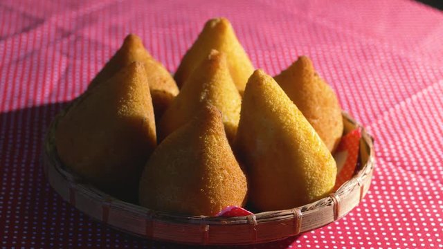 Traditional Brazilian snacks coxinha on straw dish