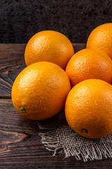 Oranges on dark wooden background.