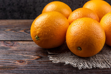 Oranges on dark wooden background.