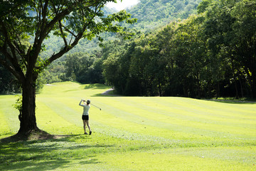 Asian woman playing golf on a beautiful natural golf course
