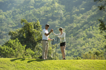 Man and woman playing golf on a beautiful natural golf course