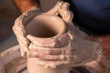 Professional potter making bowl in pottery workshop