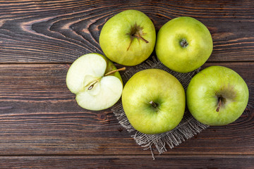 Green apples on dark wooden background.