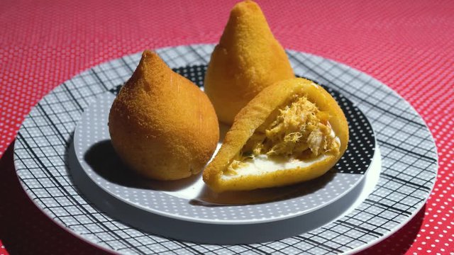Traditional Brazilian snacks coxinha on straw dish	