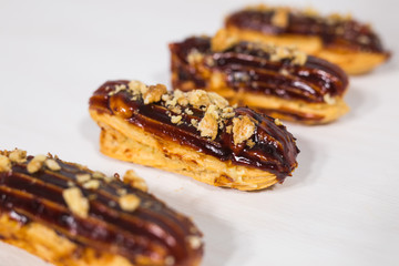 Food, desserts and bakery concept - Traditional French dessert eclairs with chocolate and nuts