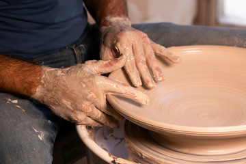 Professional potter making bowl in pottery workshop