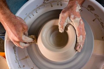 Professional potter making bowl in pottery workshop