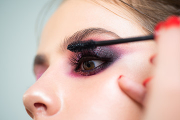 Make-up artist applying the mascara to model. Sexy Lady, Fashion, Beauty.