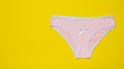 Pink women's panties on a bright yellow background. Fashionable concept. Beautiful lingerie. The...