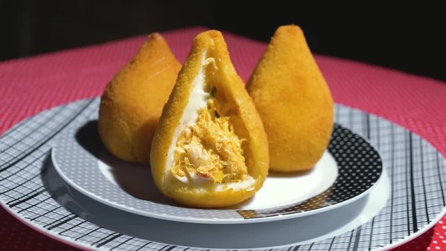 Traditional Brazilian snacks coxinha on straw dish	