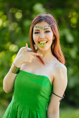 Beautiful young asian woman with slice of kiwi in mouth