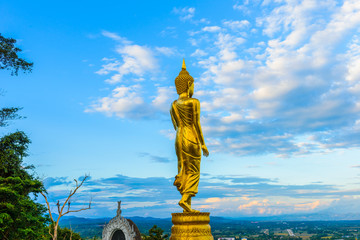 Wat Phra That Khao Noi, Nan Province, Thailand, Golden Buddha statue standing on a mountain