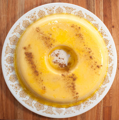 home made vanilla and cinnamon flan over a wooden table