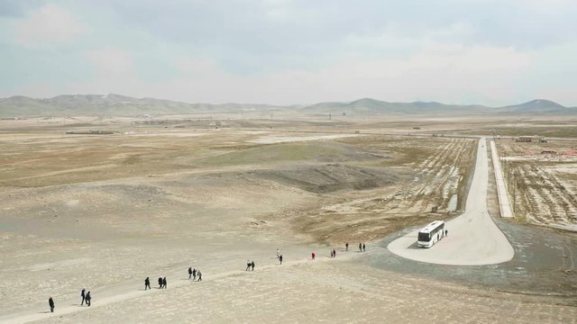 Still shot showing tourists walking back to the bus from Tepe Nush-e Jan in Iran.