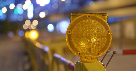 Yellow caution light in the street at night