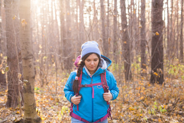 adventure, travel, tourism, hike and people concept - Attractive smiling tourist woman walking in the thick of the forest