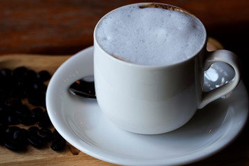 White coffee cup  and coffee beans placed on the table