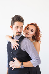 Social dance, bachata, kizomba, salsa, tango concept - Woman dressed in red dress and man in a black costume over white background