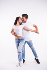 Young couple dancing social latin dance bachata, merengue, salsa. Two elegance pose on white background